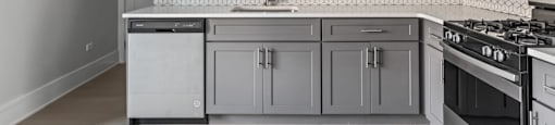 A kitchen with white cabinets and a black stove top oven.