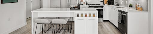 A modern kitchen with white cabinets and a large island.