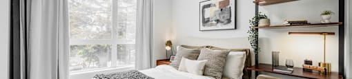 A bedroom with a large bed and a chair.
