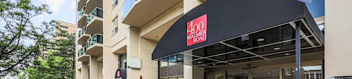 a building with a black awning and a large potted plant in front of it