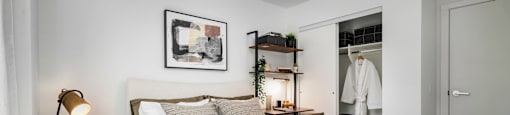 A bedroom with a large bed and a wooden nightstand.