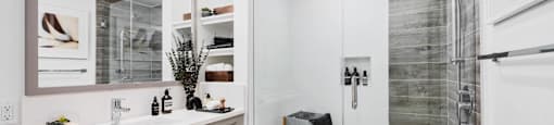 A modern bathroom with a walk-in shower and double sink vanity.