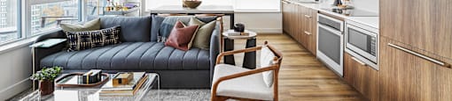 A modern living room with a grey sofa and a wooden chair.