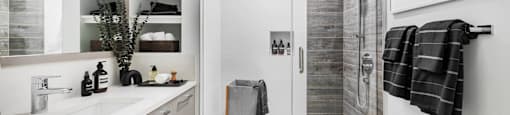 A bathroom with a walk-in shower and a vanity with a mirror.