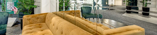 the lobby of a building with a couch and chairs
