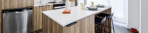 a kitchen with a large island with a white counter top