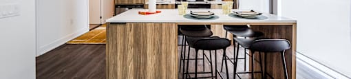 a kitchen with a center island and stools in a 555 waverly unit