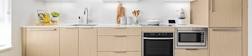 A modern kitchen with wooden cabinets and stainless steel appliances.
