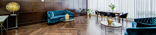 A living room with a dark blue couch and a wooden floor.