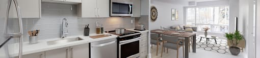 an open kitchen and living room with a dining room table