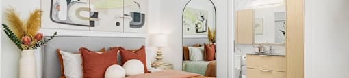 A bedroom with a bed, nightstand, and a mirror.