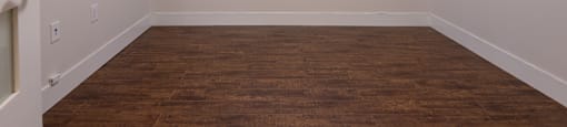 an empty room with a wood floor and white walls