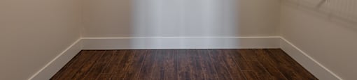 an empty room with white walls and shelves and a wooden floor