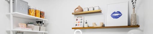 A white desk with a white chair and a white furry stool in front of it.