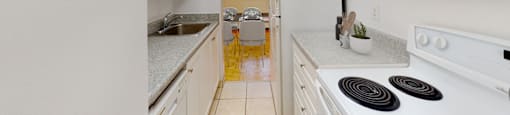 A kitchen with white appliances and cabinets.