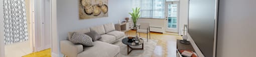 A living room with a couch, coffee table, and television.