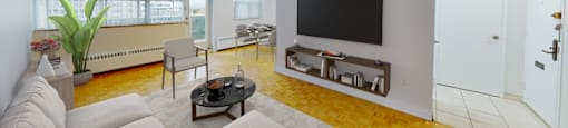 A living room with a white couch and a flat screen TV.