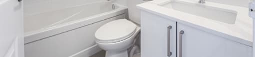 A white bathroom with a toilet, sink, and bathtub.