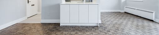 A white kitchen with a wooden floor and a white cabinet.