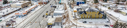 A view of a city with roads, buildings, and a snowy landscape.