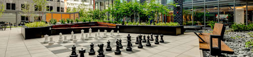 A giant chess board is set up on a patio.
