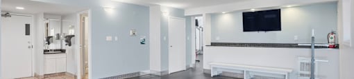 A spacious room with a grey floor and white walls.