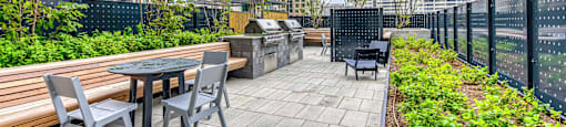A patio with a table and chairs overlooking a cityscape.