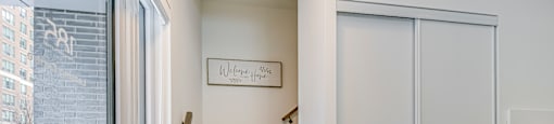 A white door with a glass window is open to a hallway.