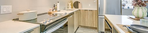A modern kitchen with wooden cabinets and stainless steel appliances.