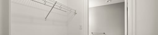 A white toilet in a small bathroom with a white wall and a white door.