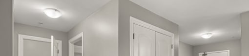 A room with white doors and beige tiled floors.