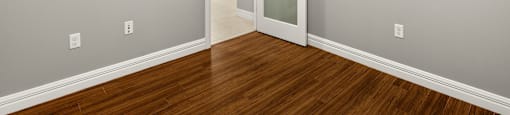 A room with a wooden floor and a white door.