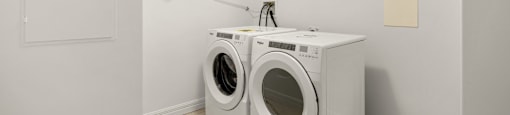 A white laundry room with a washer and dryer.