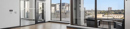 a living room with wood floors and glass windows and a balcony