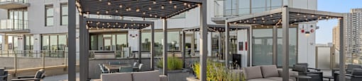 an outdoor patio with couches and tables in front of a building