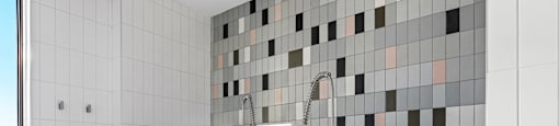 a white tiled bathroom with a shower and a sink