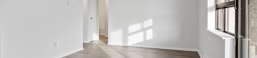 A room with wooden flooring and white walls.