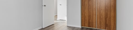A room with a white door and a brown wardrobe.