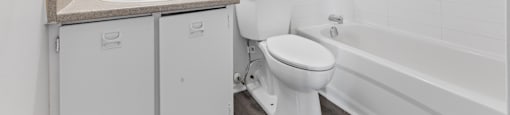 A white bathroom with a sink, toilet and bathtub.