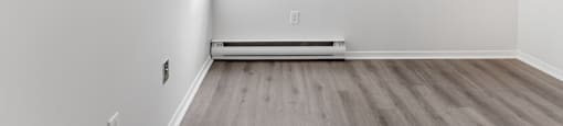 A room with a window and a radiator on the floor.