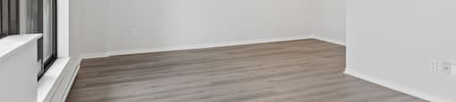 A room with wooden flooring and white walls.