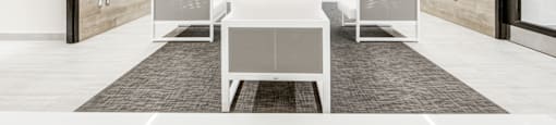 A modern living room with white furniture and a grey carpet.