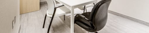 A conference room with a white table and chairs.