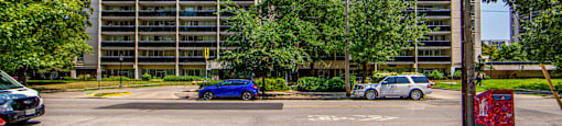 A tall building with a parking lot in front of it.
