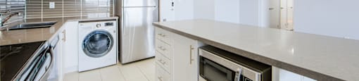 A kitchen with white cabinets and appliances.