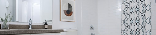 A white bathroom with a toilet, sink, and shower.