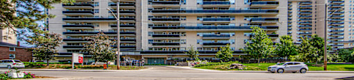 A large, modern building with a parking lot in front.