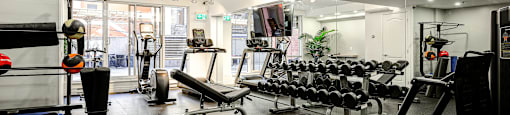 A gym with a variety of equipment including weights and machines.