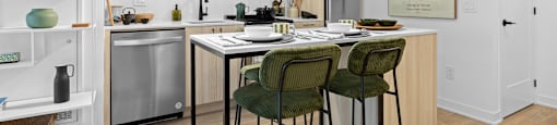A kitchen with a table and chairs in front of it.