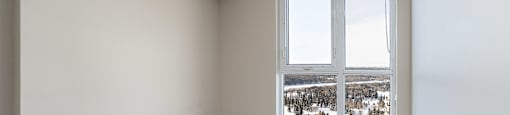 A room with a large window and a carpeted floor.